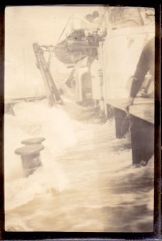 a photograph by francis davies aboard rrs william scoresby with unidentified but brave crew member hanging onto the deck, 1929